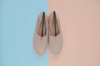 Bej renkli kumaş espadrilles ayakkabılar bej mavisi arka planda. Açık bej renkte açık renkli ayakkabılar. Yaz sezonu için şık ayakkabılar.