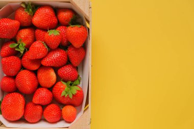 Çilekler sarı arka planda. Çilek seti. Yukarıdan bak. Yaz çileği hasadı. Sağlıklı Tatlı Tatlı. 