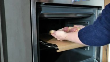 Pizza pişirme. Elleri fırının ızgarasına çiğ pizza koyuyor. Yüksek kalite 4k görüntü
