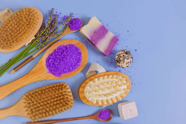 stock image lavender extract cosmetic. Lavender bath salt with lavender extract and body care brushes on a blue background. View from above. Aromatherapy and spa