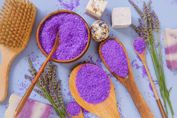 stock image Lavender bath salt with lavender extract and body care brushes on a blue background. View from above.body cosmetic with lavender extract.Aromatherapy and spa