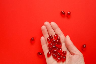 Kırmızı zemin üzerinde kril yağı kapsülleri. Omega yağ asitleri. Sağlıklı beslenme ve gıda takviyeleri. Beslenme takviyeleri ve gıda takviyeleri