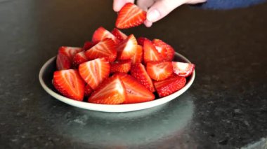 Çilek yeme, çilek mevsimi. Eller tabaktan bir çilek alır. Sağlıklı Tatlı Tatlı. Yüksek kalite 4k görüntü