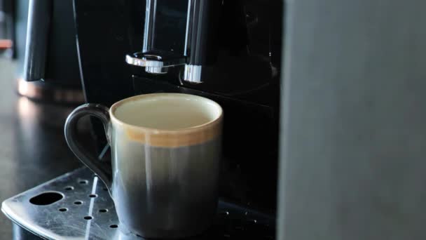 朝のコーヒー白いコートの手は コーヒーマシンにマグカップを置きます 黒コーヒーを作るプロセス 朝のさわやかな飲み物 伝統的な朝のホットドリンク 高品質4K映像 — ストック動画