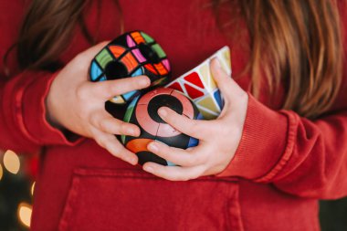 Eğitici oyuncaklar. Çocukların elinde farklı şekillerde bulmacalar. Eğitici oyuncaklar. Bulmaca ve yapıcılar kavramı. Sorunları çözmek için oyun. Yuvarlak ve üçgen bulmacalar. 