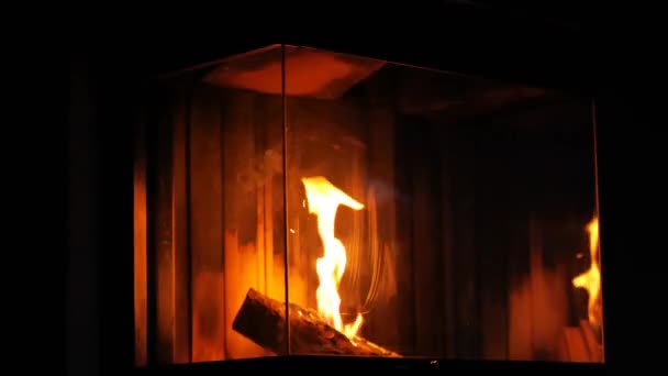 暗い部屋で暖炉を燃やす 暖炉のガラスの後ろの炎 居心地の良い暖かい雰囲気 高品質4K映像 — ストック動画