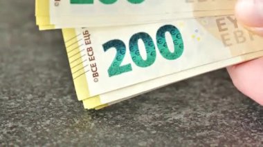 Para sayma. Siyah masa geçmişine 200 avroluk yakın plan banknotlar. Avrupa ülkelerindeki giderler ve gelirler. Yakın planda bir paket para. 4k görüntü