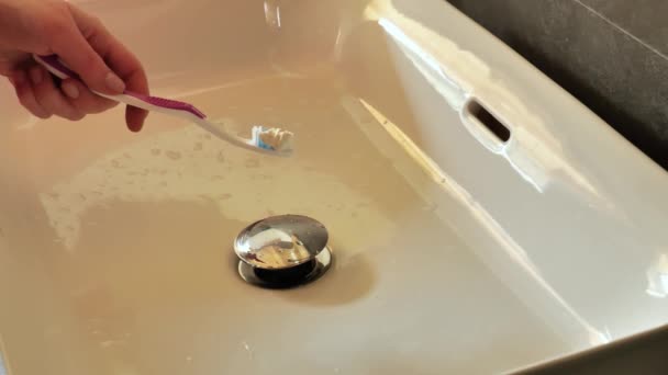 Zahnreinigung Zahnbürste Mit Zahnpasta Der Hand Unter Leitungswasser Bad Zeitlupe — Stockvideo