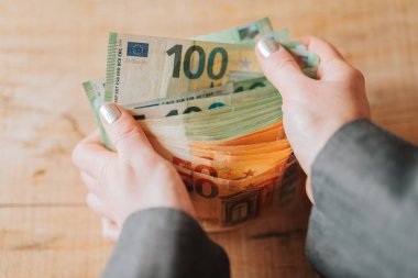 Avro parası. Kadın eli para sayar. Avro Bölgesi 'nde kadın ticareti ve girişimciliği. İş ve finans kavramı. Faturalar kadınların yakın planında. Avrupa Birliği' nde kadın maaşları. 