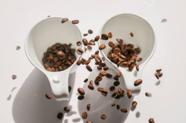 Beyaz fincanlar ve düşen kahve çekirdekleri. Kahve havalanması. Beyaz bardakta kahve. Geleneksel sabah içkisi. Sabah içeceği..