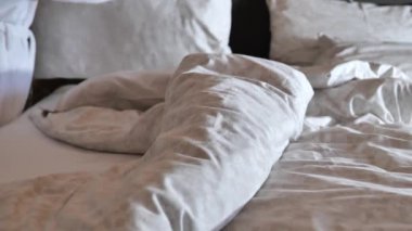 Yatak yapma. Kadın eli yataktaki yastıkları düzeltir. Yatak odasında sabah temizliği. Düzen ve temizlik kavramı. 4k görüntü