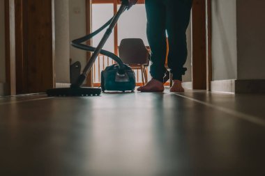 Koridor temizliği. Adam yerleri süpürüyor. Erkekler temizlik. Temizlik ve ev temizliği konsepti. Temizlik malzemeleri. Elektrik süpürgesi. 