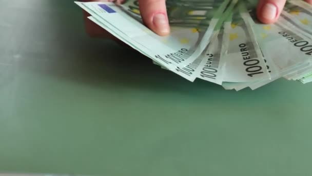 緑の背景にユーロ紙幣を数える ヨーロッパ連合のお金 ユーロ圏での収入と支出 グリーンバックグラウンドで100枚の紙幣の積み重ね — ストック動画