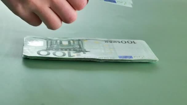 緑の背景に100ユーロ紙幣 ユーロ紙幣を数える手 ヨーロッパ連合のお金 ユーロ圏での収入と支出 4K映像について — ストック動画