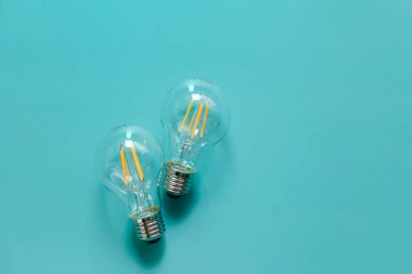 Elektrik ve enerji tasarrufu. Ampuller mavi arkaplandan tasarruf ediliyor. Elektrik fiyatları. Elektrik faturaları. Yukarıdan bak. Enerji sektöründe kriz var. 