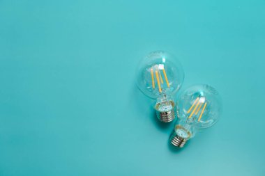 Elektrik ve enerji tasarrufu kavramı. Ampulleri mavi bir arkaplanda saklayan enerji. Elektrik fiyatları. Elektrik faturaları. Yukarıdan bak. Enerji sektöründe kriz var. 