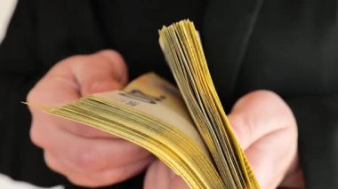 Avro parası. Bir yığın banknot yakın planda el değiştiriyor. 200 Euro 'luk paket kadın ellerinde, yakın plan. 4k görüntü
