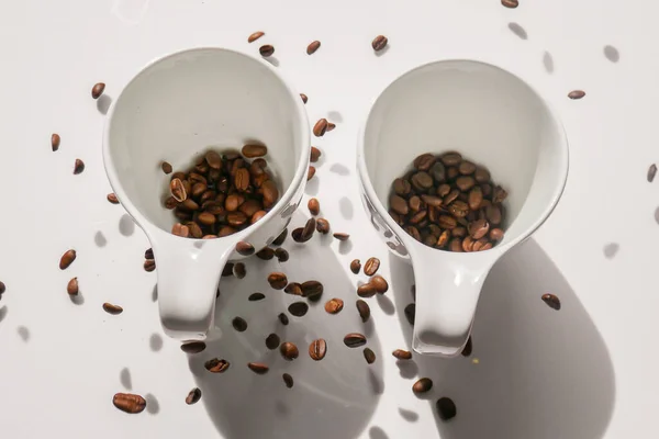 white cups and falling coffee beans.coffee levitation. Traditional morning drink.Morning refreshing drink.
