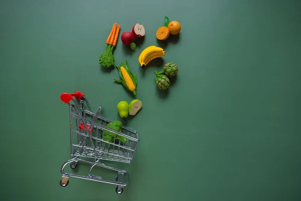 Шоппинг Пищевой Фон Тележка Супермаркета Декоративными Овощами Фруктами Зеленом Фоне — стоковое фото