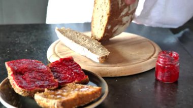 Taze dilimlenmiş ekmek. Kadın elleri bir somun gevrek ekmeği yakın plan kesiyor. 4k görüntü