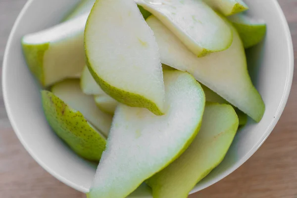 Sliced pear.cutting green pear into a plate .Fruit cut. Healthy fruit snack. fresh fruits in the diet