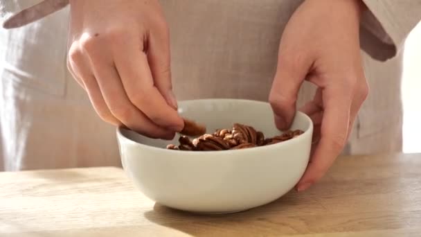 パカナッツ 女性はナッツをカップに入れる 新鮮なオーガニックナッツ スローモーション シェルドペカン 健康的な脂肪 ケトダイエット成分 — ストック動画