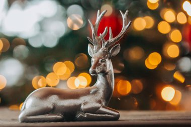  Noel süsleri. Kırmızı ve altın rengindeki Noel geyiği, Bokeh 'in geçmişini bulanıklaştırdı. Kış tatili için evi dekore ediyor.