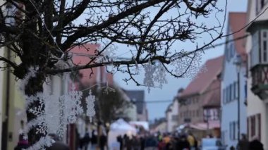 Noel pazarları, kar taneleri ve yürüyen insanlar Almanya 'daki Noel pazarında. Yumuşak odaklanma. Avrupa' da Noel zamanı. 4k görüntü