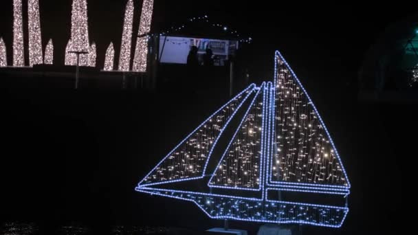 Weihnachtsschmuck Schiff Aus Leuchtenden Girlanden Der Dunkel Schimmernde Straßenkulisse Auf — Stockvideo