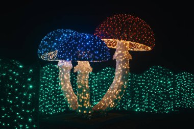 Çelenk mantarları. Noel süslemeleri. Karanlıktaki çelenklerden parlayan Noel figürleri. Çelenklerle kurulmuş..