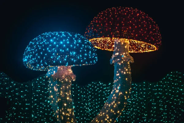 Çelenklerden Noel figürleri. Çok renkli çelenklerden parlayan dev mantarlar. Çelenklerle kurulmuş..