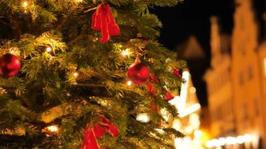 Noel Rothenburg ob der Tauber. Yumuşak odaklanma. Topları ve parlak çelenkleri olan Noel ağacı. Kasabanın bulanık arka planı. Akşamları Noel 'in sokakları. 4k görüntü