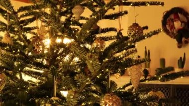 Noel süslenmiş köknar ağacı, parlak bir odada oyuncaklarla. 4k görüntü