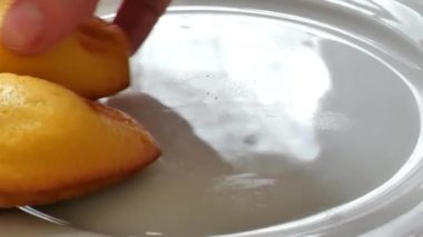 Pastalar, tatlılar ve tatlılar. El, kurabiyeleri yakın plan bir tabağa koyar. 4k görüntü