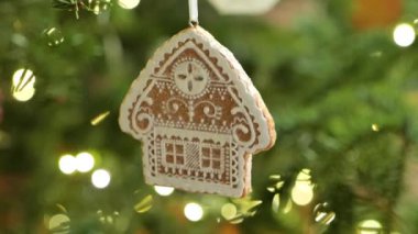 Noel oyuncakları. Güneşin altında Noel ağacı dalında seramik zencefilli kurabiye oyuncağı. Noel geleneği.