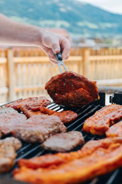 Barbekü ve ızgara. Adam ızgarada et kızartıyor.. 
