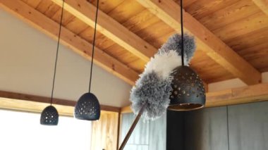 Lambayı temizliyorum. Toz temizliyorum ve temizlik yapıyorum. Pipidastr metal lambalardaki tozu siliyor. Tüylü toz bezi ve kolye ışıkları. 4k görüntü