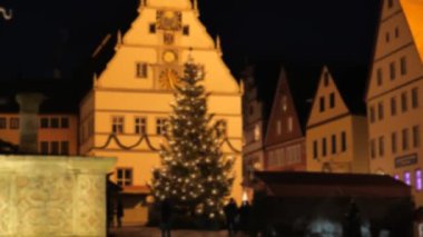 Rothenburg 'da Noel' de. Almanya. Şehir meydanındaki insanlar Noel ağacının yanında. Bulanık odaklanma. Avrupa 'da Noel zamanı. 4k görüntü