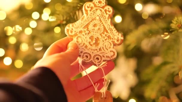 手のヴィンテージクリスマスツリーのおもちゃ クリスマスのヴィンテージおもちゃ お祝いのクリスマスツリーにガーランドの装飾的な陶磁器クッキーとボケ 4K映像について — ストック動画