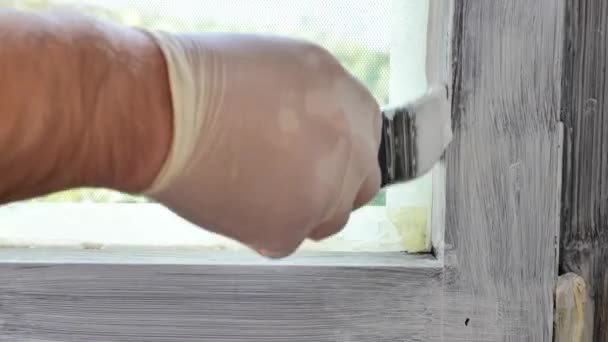ウィンドウを描く 木製フレームの修理 男性の手は白いペンキが付いている木製の窓枠を塗ります 修理プロセス 4K映像について — ストック動画