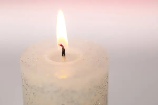 Burning candle close-up.Candle flame.White candle .Beautiful background with a candle in pastel colors