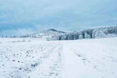 Mavi gökyüzü, kar yağışı ve karlı mavi bulutların altında orman ve dağ. Kış havası. Kış buzlu duvar kağıdı. Kış doğası. Doğal güzel doku.. 