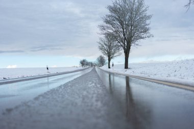  Road traffic in winter.Ice on the road. Slippery winter road.Trees in the snow along the road. Winter beautiful landscape.Danger of roads in winter  clipart