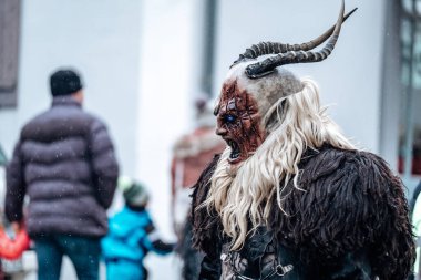 Krampus iblisi. Almanya 'da karnaval geçitleri. Karnaval kostümleri ve karakterleri. Avrupa sokaklarında kış kostüm gösterileri. Krampus canavarının şeytan yüzü. Geleneksel kültürel folklor