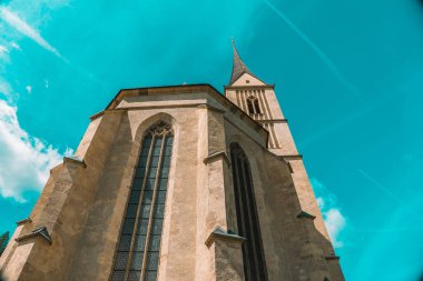 Avusturya 'daki St. Leonard Kilisesi' nin parlak mavi bir arka planı var. Alt manzara. Dışarıdaki Katolik Kilisesi mimarisi. Gotik tarzda kilise binası. Hıristiyan ve katolik inanç sembolü.