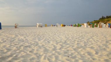 Fehr Adası, Kuzey Denizi, Almanya 'nın beyaz kumlu plajları. Deniz kıyısındaki plaj kutuları. Alman sahil tatil beldelerindeki plaj sepetleri. 4k görüntü