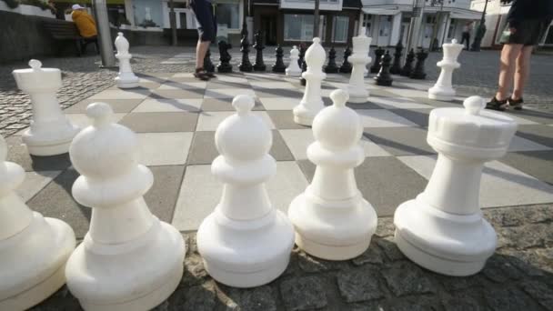 街头棋子 心理游戏 人们在街上的棋盘上玩着巨大的棋子 街头游戏和户外娱乐活动 爸爸和女儿下棋 4K镜头 — 图库视频影像