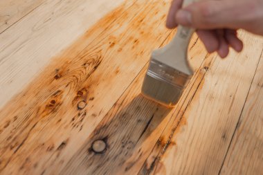 Odun için yağ ve vernik. Erkekler ahşap tahtaları yağla boyarlar. Koruyucu yağlı bir odunun döllenmesi. Ahşabın yağla doldurulması. Ahşap yüzeyi hasardan koruyor..