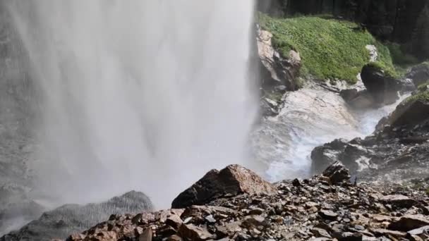 水流缓慢地下降 水流在岩石和巨石上冲刷着 水流湍急 有水滴 有水花飞溅 瀑布从高高的悬崖上涌出的强大的水流 缓慢的运动 — 图库视频影像