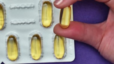 Omega yağ asidi kapsülleri, kadın ellerine yerleştirilmiş parlak kabarcıklar. Beslenme takviyeleri ve kadın beslenmesinde vitaminler. Kadın sağlığı için balık yağı. Omega yağ asitleri. Doğal takviyeler ve vitamin. 4k
